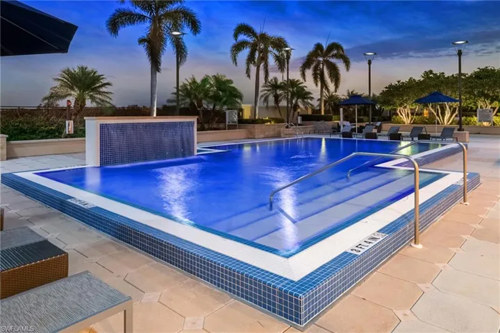 Pool at dusk with a community pool and a patio