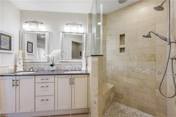 Full bathroom featuring a walk in shower and double vanity
