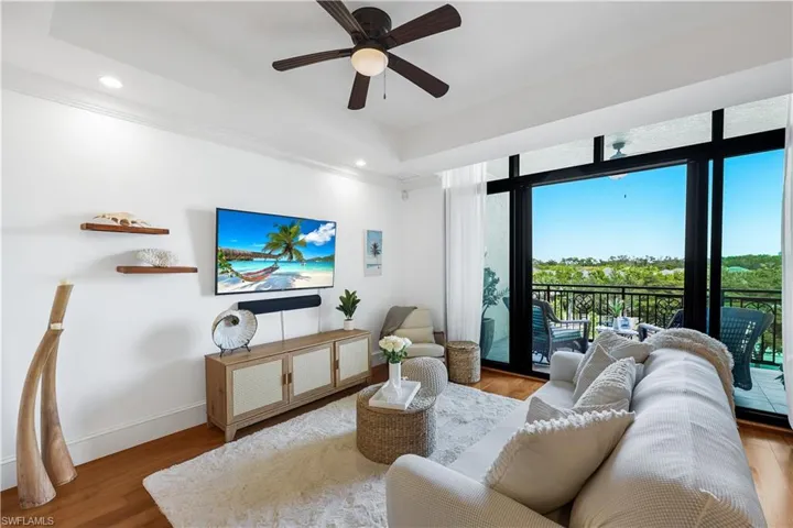 Living area with wood finished floors, ceiling fan, recessed lighting, and ornamental molding