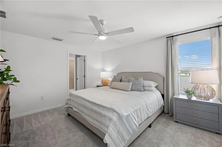 Bedroom with light carpet and a ceiling fan