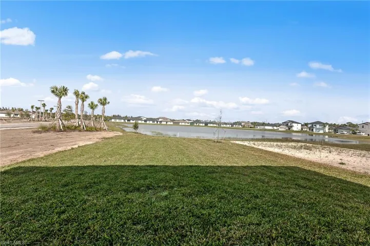 View of grassy yard featuring a water view and a residential view