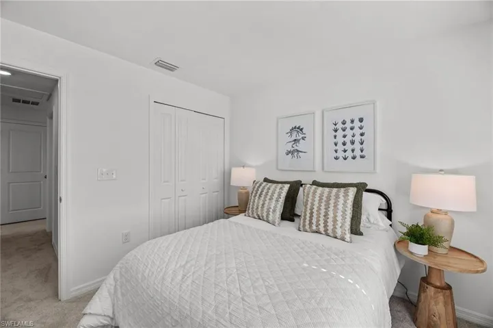 Carpeted bedroom featuring a closet and baseboards