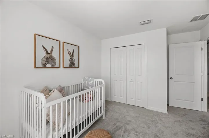 Bedroom featuring carpet floors, a closet, and a nursery area