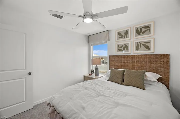 Carpeted bedroom featuring a ceiling fan and baseboards