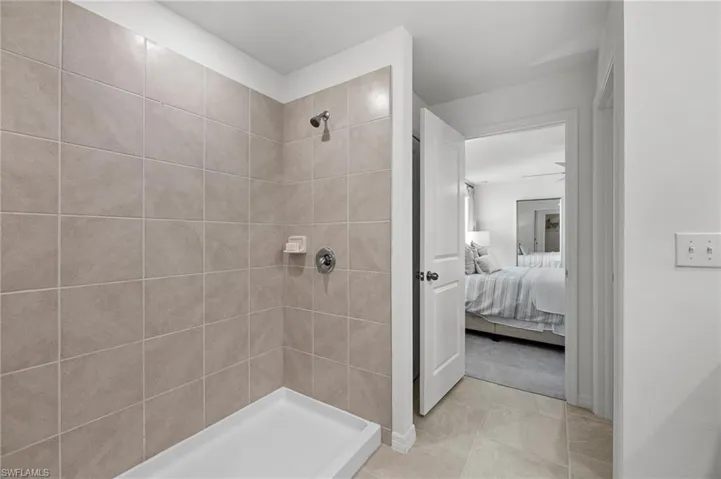 Bathroom featuring ensuite bath, a tile shower, and tile patterned flooring
