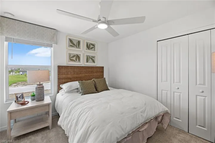 Bedroom with carpet, a closet, and a ceiling fan