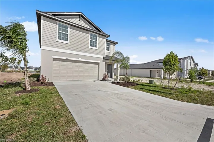 View of front of house featuring driveway, a garage, and stucco siding