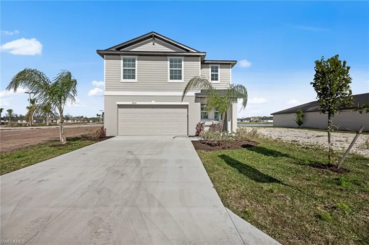 View of front of property with driveway, a garage, a front lawn, and stucco siding