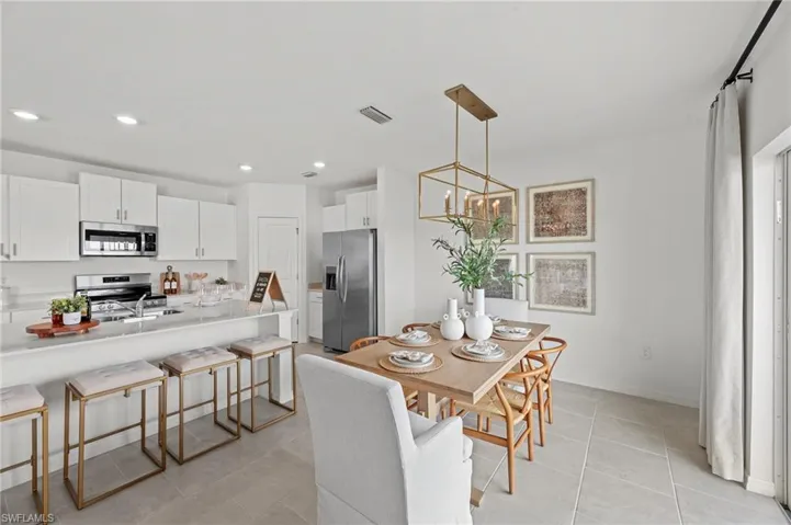 Dining area featuring a chandelier, light tile patterned floors, and recessed lighting