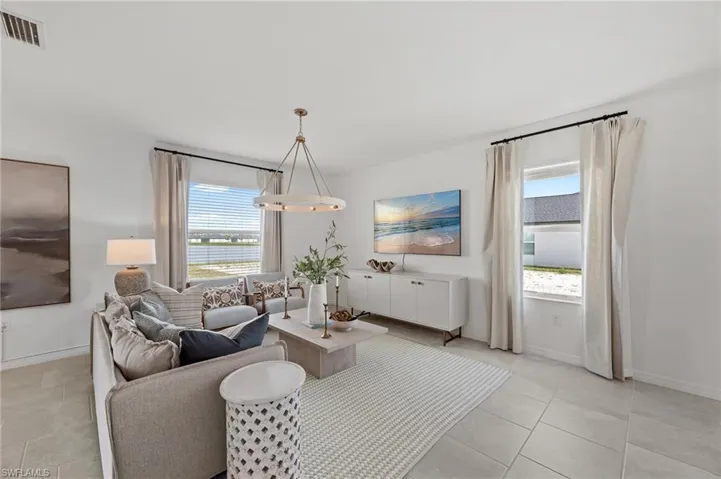 Living area with plenty of natural light, light tile patterned floors, and a water view