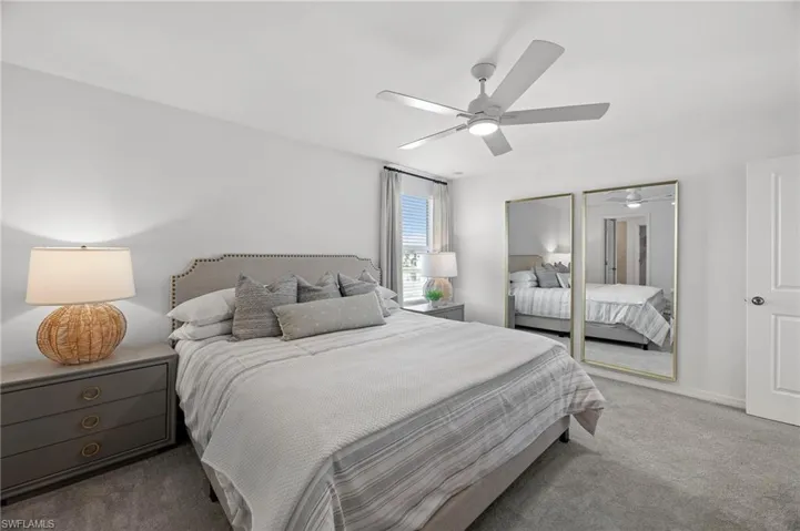 Carpeted bedroom featuring a ceiling fan