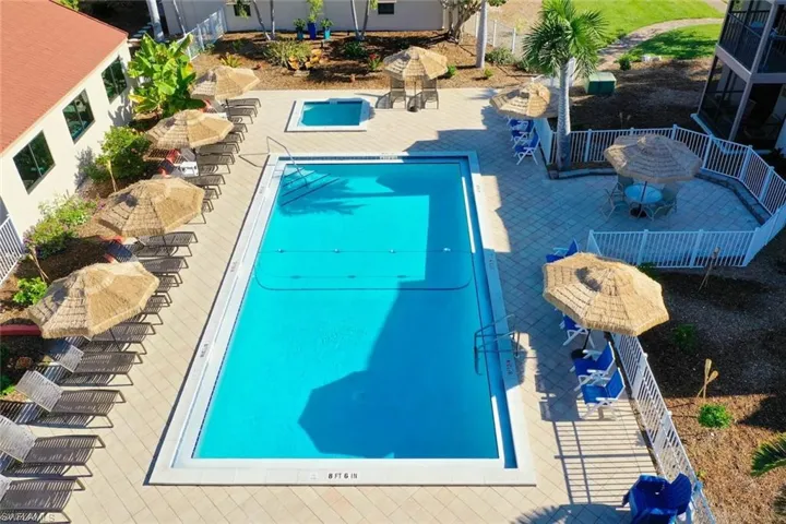 Rectangular swimming pool with a connected spa, surrounded by a paver deck