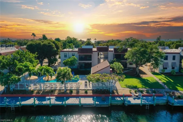 Waterfront property featuring multiple boat slips, a swimming pool, and mature landscaping