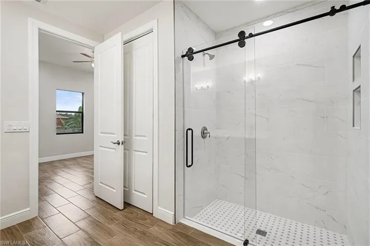 Bathroom featuring a stall shower and wood finish floors