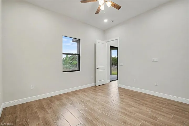 Empty room with wood finish floors and a ceiling fan