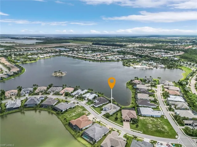 Aerial view of property and surrounding area with nearby suburban area and a large body of water