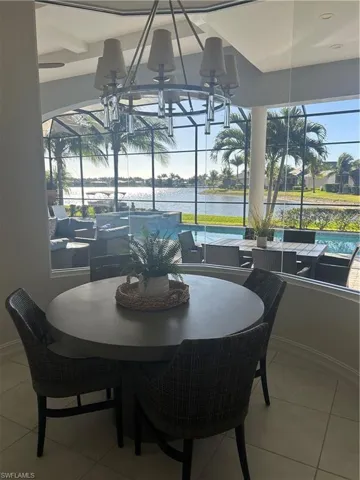 Tiled dining area with a water view and a sunroom