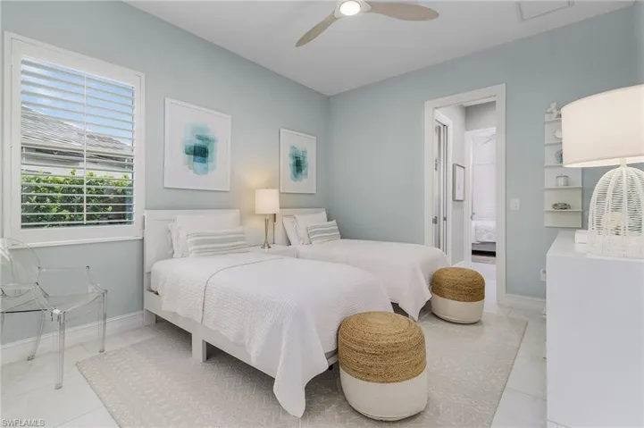Bedroom with a ceiling fan and light tile patterned flooring
