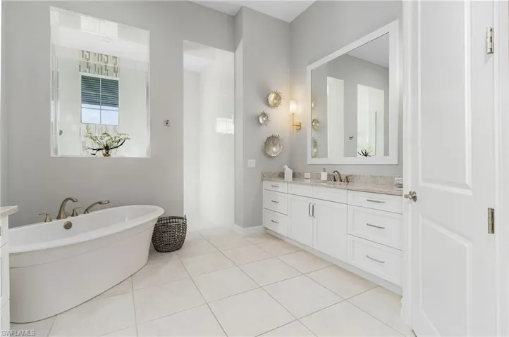 Full bath featuring vanity, a freestanding bath, tile patterned floors, and walk in shower