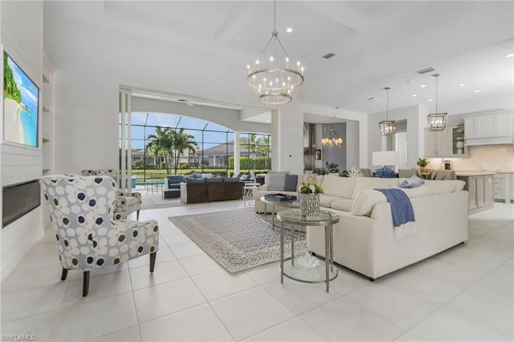 Living area featuring beamed ceiling, light tile patterned flooring, recessed lighting, a chandelier, and coffered ceiling