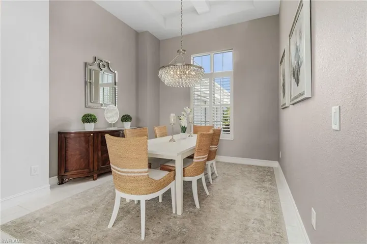 Dining area featuring a raised ceiling and a chandelier