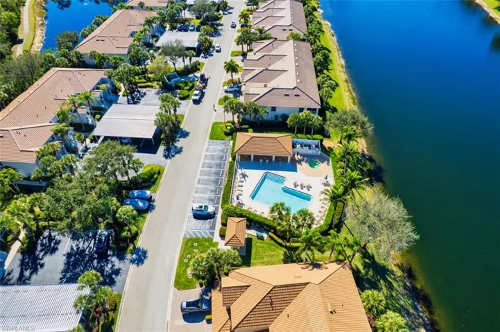 Aerial perspective of suburban area with a large body of water and a pool