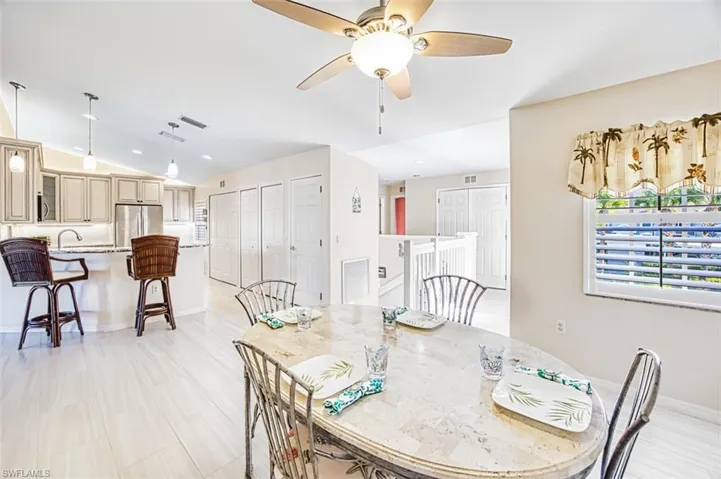 Dining space with vaulted ceiling, ceiling fan, and recessed lighting