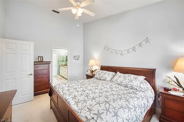 Bedroom with a ceiling fan, connected bathroom, and light wood finished floors