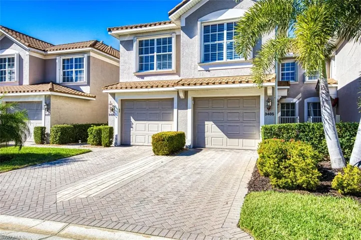 Mediterranean / spanish home with decorative driveway, an attached garage, stucco siding, and a tiled roof