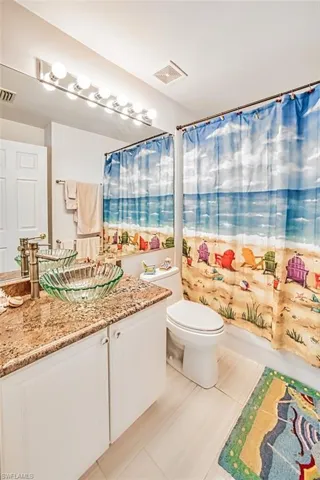 Full bathroom featuring vanity, light tile patterned floors, and shower / tub combo with curtain