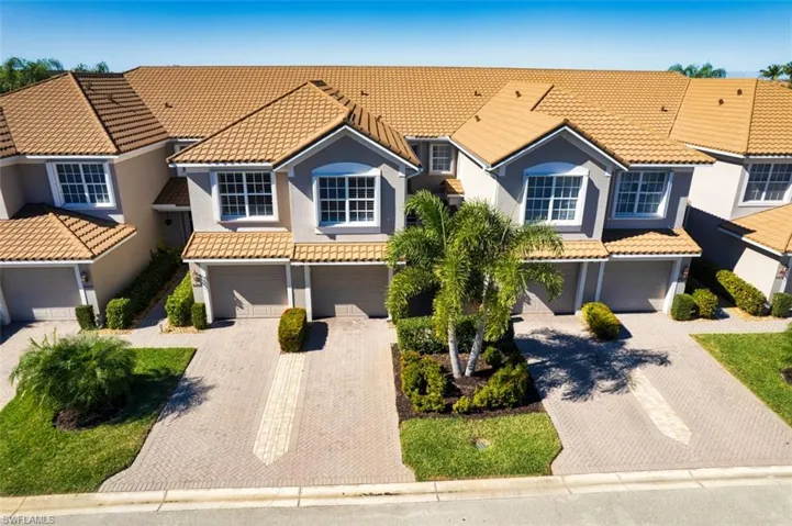 View of front of house with a garage, stucco siding, driveway, and a residential view