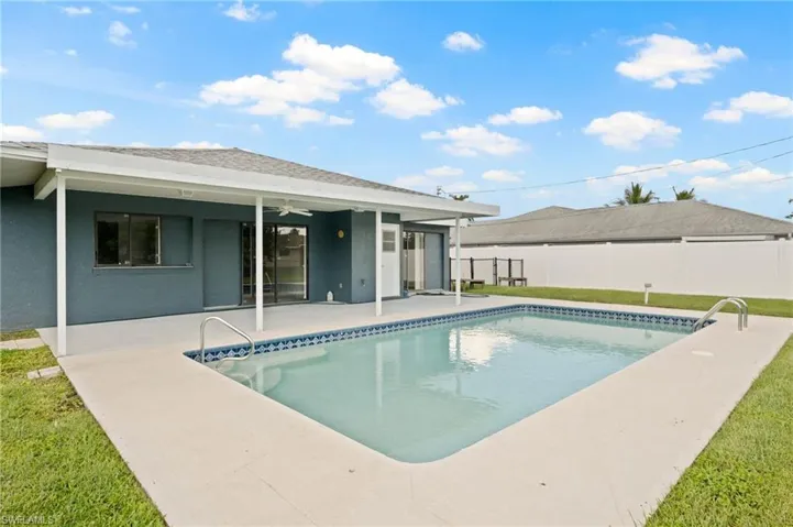 View of pool with a lawn, ceiling fan, and a patio area