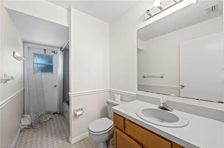 Full bathroom featuring shower / bath combination with curtain, vanity, and toilet