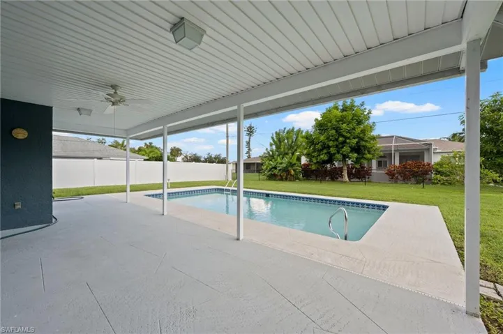 View of pool with a lawn, ceiling fan, and a patio