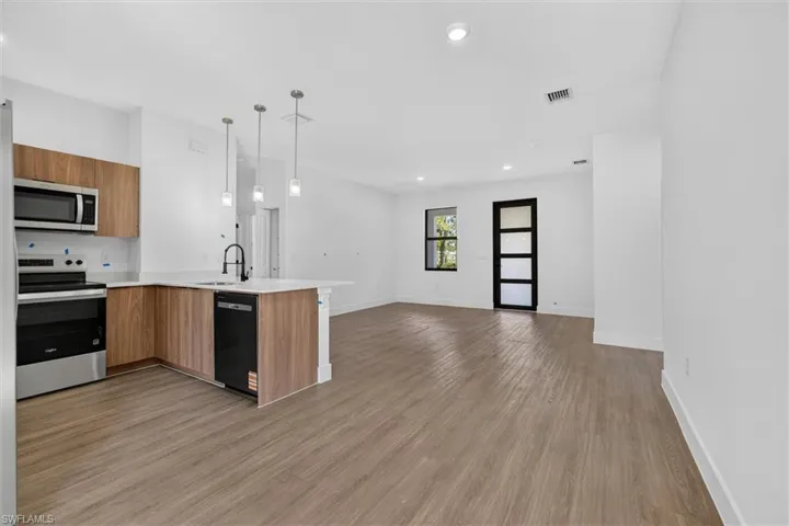 Open concept living space featuring wood-finish flooring throughout
