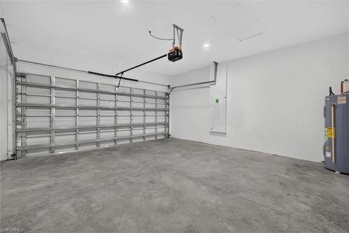 Spacious garage featuring a concrete floor, white painted walls, and an overhead garage door