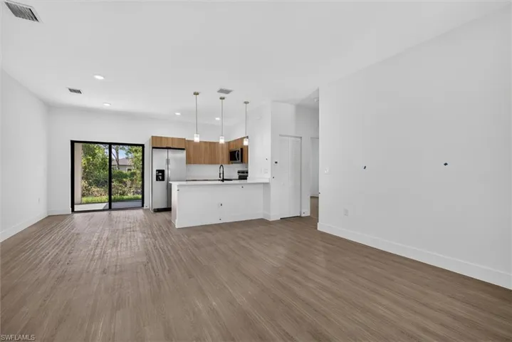 Open-concept living space featuring wood-finish flooring and recessed lighting