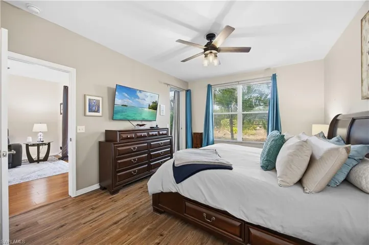 Bedroom featuring dark wood-type flooring, ceiling fan, and access to outside