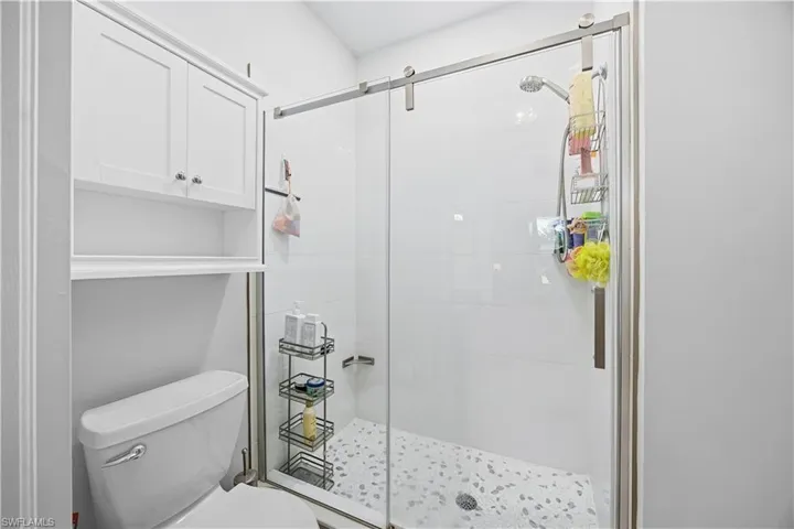 Full bathroom featuring toilet and a stall shower