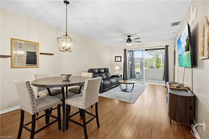 Dining room featuring wood finished floors, a chandelier, and a ceiling fan