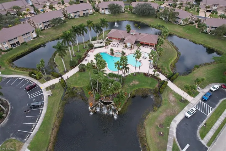 Aerial view of property and surrounding area featuring a large body of water and a pool