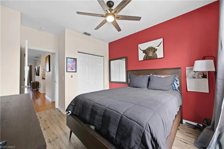 Bedroom with light wood-style floors, a closet, and a ceiling fan