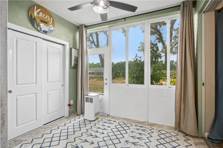 Entryway with ceiling fan and a textured wall