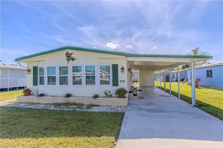 Manufactured / mobile home with a carport and a front lawn