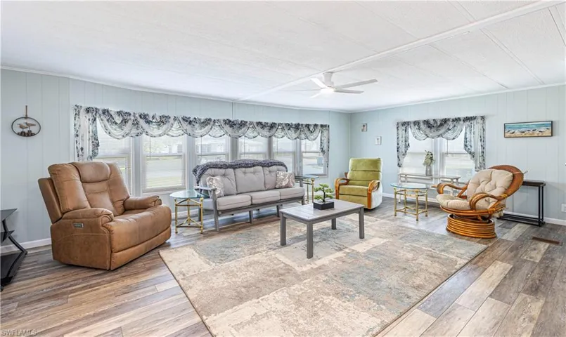 Living room featuring a wealth of natural light, ceiling fan, and hardwood / wood-style flooring