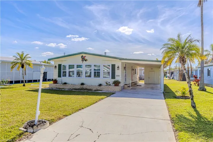 Manufactured / mobile home with a carport and a front yard