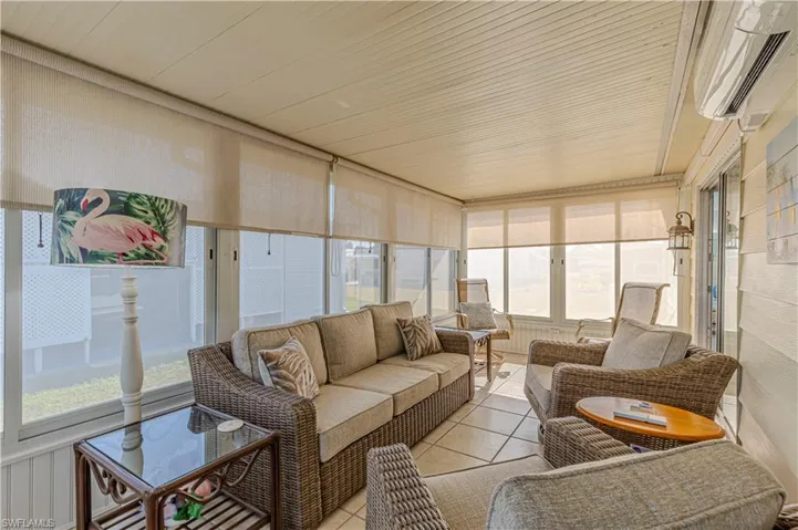 Sunroom featuring an AC wall unit, plenty of natural light, and wooden ceiling