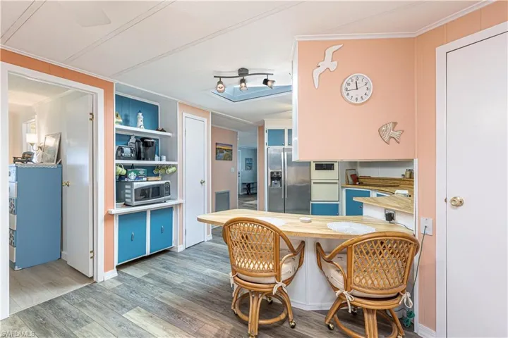 Dining area with wood-type flooring and ornamental molding