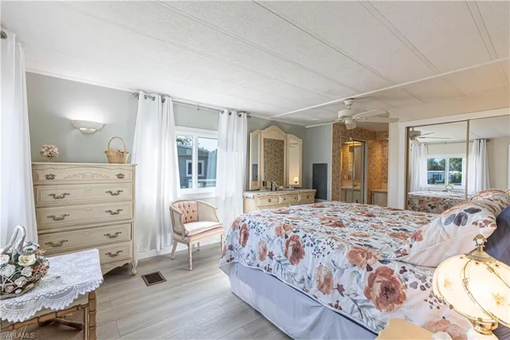Bedroom with ceiling fan, light hardwood / wood-style floors, and a textured ceiling
