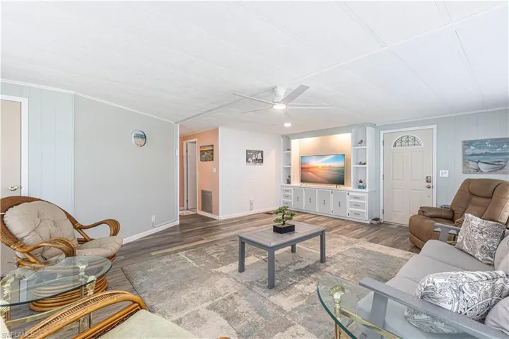 Living room featuring hardwood / wood-style floors, ceiling fan, and built in shelves
